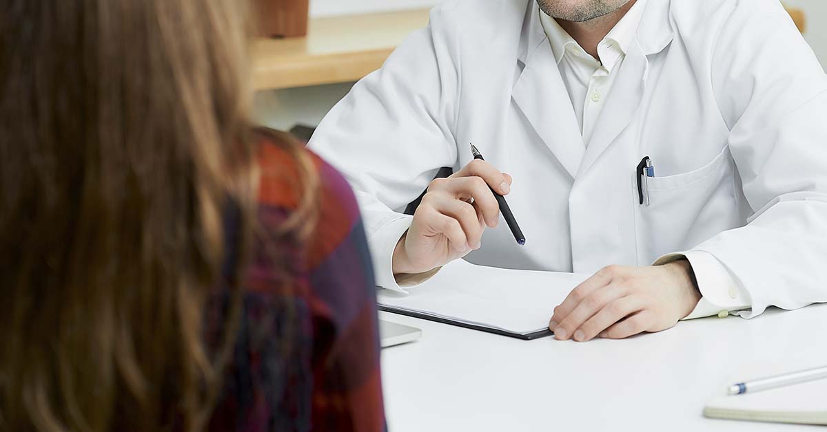 Endometriose profunda: o que é, sintomas graves e tratamentos especializados 3 médico conversando com paciente durante uma consulta médica